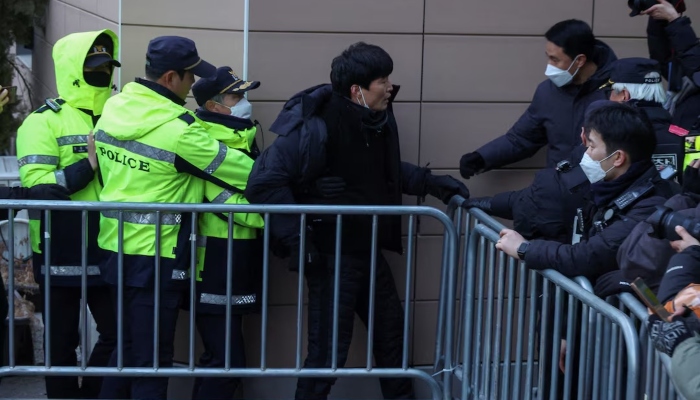 Police officers detain a man who jumped over a fence during a Pro-Yoon protest rally outside a court, in Seoul, South Korea, January 18, 2025. — Reuters