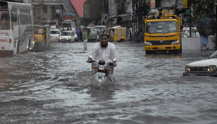 A man rides on a motorcycle amid flood waters along a road during the monsoon season in Rawalpindi, Pakistan July 19, 2023. — Reuters