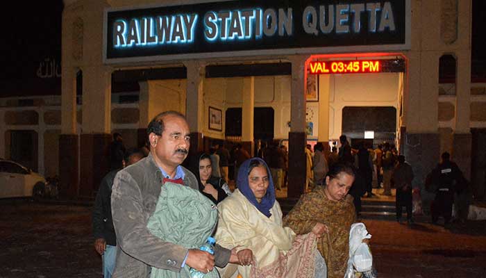 Passengers who were rescued from a train after it was attacked by separatist militants, walk with their belongings at the Railway Station in Quetta, Balochistan, March 12, 2025. — Reuters