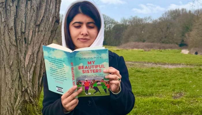 Malala Yousafzai reads My Beautiful Sisters by Khalida Popal in a park. — Instagram@malala