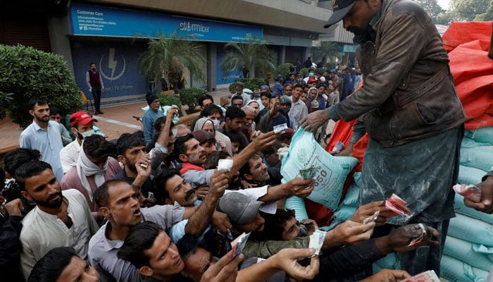 Men reach out to buy subsidised flour sacks from a truck in Karachi, Pakistan January 10, 2023. — Reuters