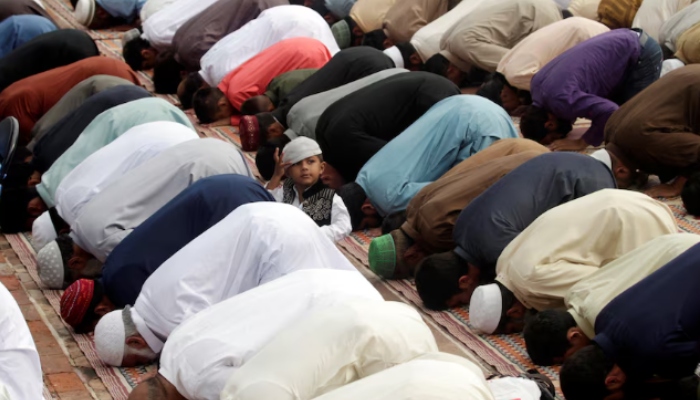 A boy sits amidst Muslims performing the Eid al-Adha prayer at a mosque in Rawalpindi, Pakistan, September 2, 2017. — Reuters