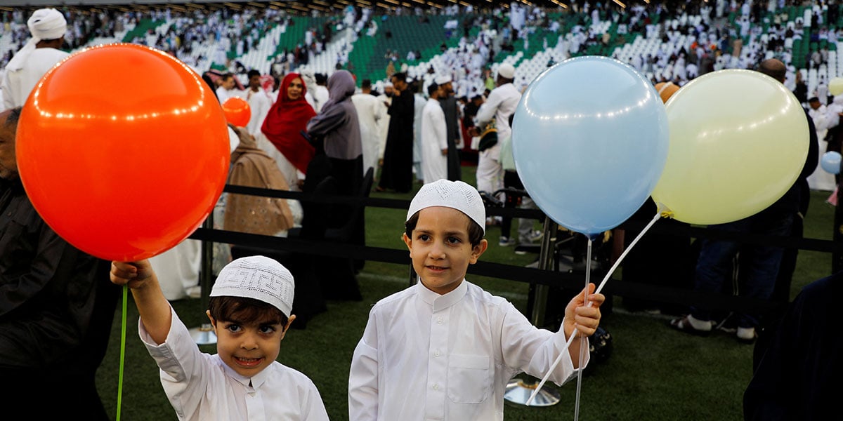Children hold balloons as people gather to attend Eid ul Fitr prayer at Education City Stadium, in Al Rayyan, Qatar, March 30, 2025. — Reuters