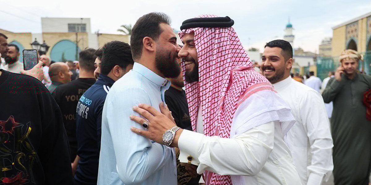 People exchange greetings after Eid prayer on a street in Baghdad, Iraq, on March 30, 2025. — Reuters