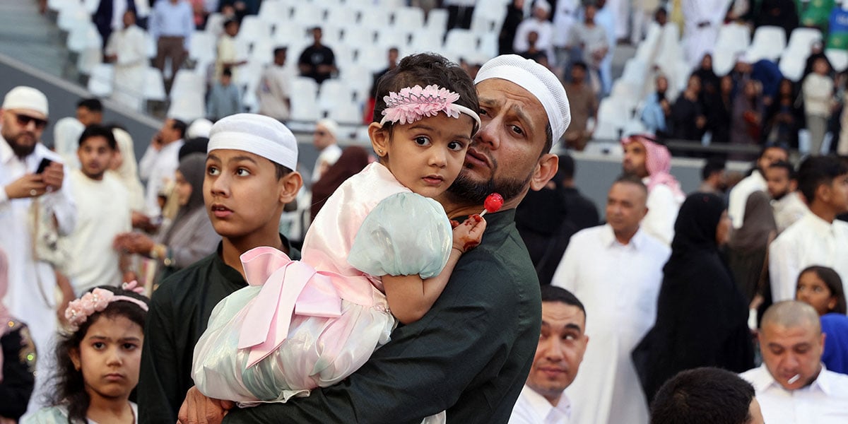 A man holds a child after performing Eid prayer at Education City Stadium, in Al Rayyan, Qatar, March 30, 2025. — Reuters