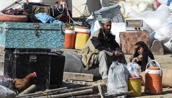 Afghan refugees sit next to their belongings before crossing the Pakistan-Afghanistan border in Chaman on November 8, 2023. — AFP
