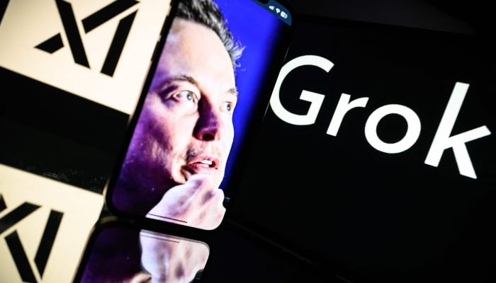 This photograph, taken on January 13, 2025, in Toulouse, shows screens displaying the logo of Grok, xAI, and its founder, South African businessman Elon Musk. — AFP