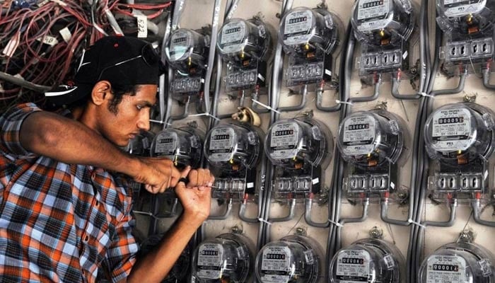 A technician fixes a metre at a residential building. — AFP/File