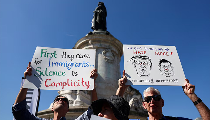 People hold placards on the day of a Hands Off! demonstration against US President Donald Trump and his adviser Elon Musk as part of an anti-Trump and anti-Tesla worldwide movement, at Place de la Republique in Paris, France, April 5, 2025. — Reuters