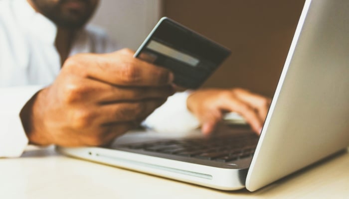 This representational image shows a person entering card details into a laptop. — Unsplash
