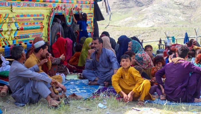 Afghan refugees deported from Pakistan, sit beside trucks upon their arrival near the Afghanistan-Pakistan Torkham border in Nangarhar on April 10, 2025. — AFP