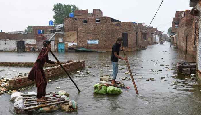 Men paddle on makeshift rafts as they cross a flooded street, amidst rainfall during the monsoon season in Hyderabad, August 24, 2022. — Reuters