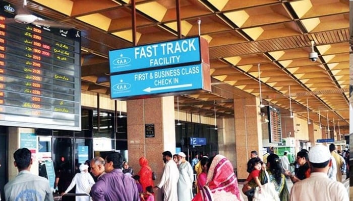 An undate image of people standing at the Jinnah International Airport in Karachi to receive passengers. — AFP/File