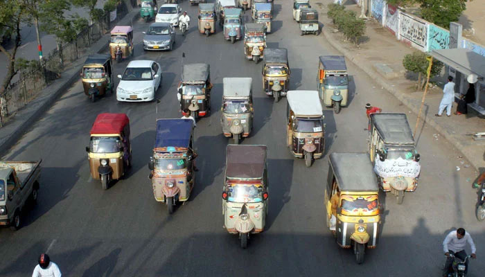 Qingqi rickshaws are pictured at a busy road in Karachi. — PPI/File