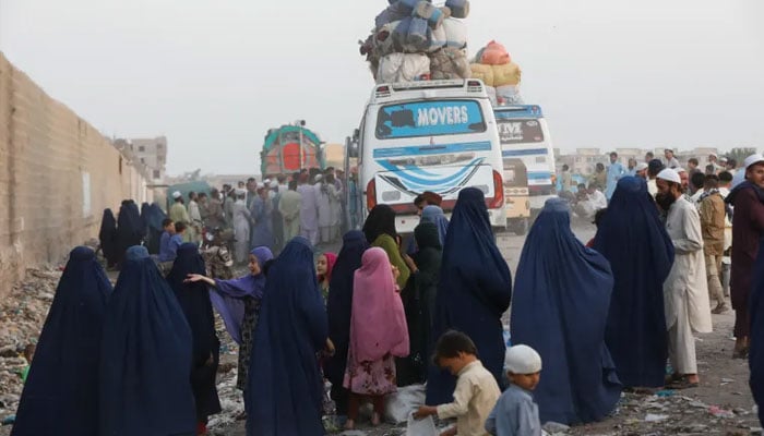 Afghan people gather to board buses as they prepare to return home, at a bus stop in Karachi. — Reuters/File