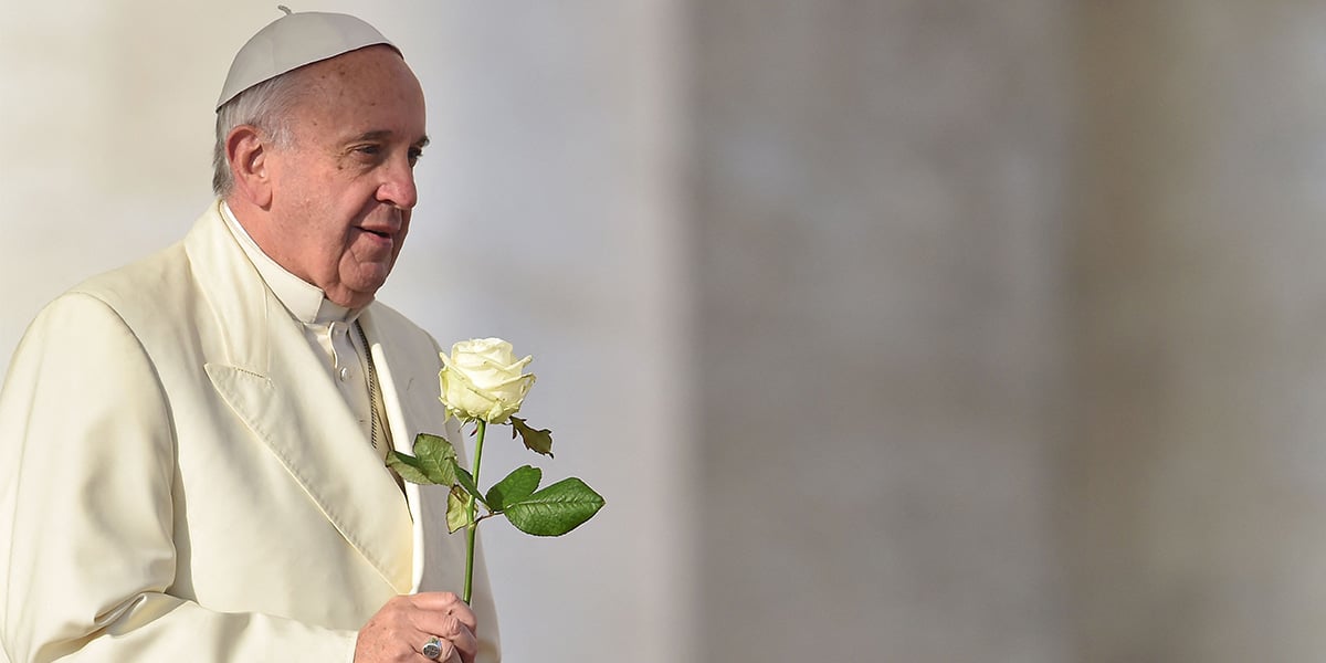 Pope Francis brings a white rose to the Virgin Mary during his weekly general audience at St Peters square at the Vatican on December 9, 2015. — AFP