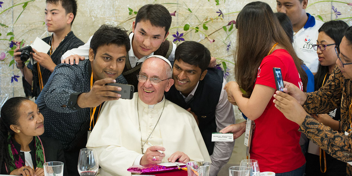 Pope Francis (C) poses for a selfie as he meets young people at the Major Seminar in Daejeon, on August 15, 2014. — AFP