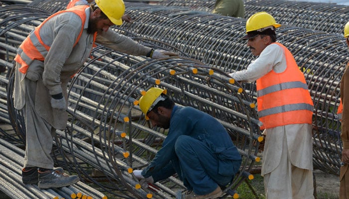 Labourers work at a construction site in Peshawar. — AFP/File