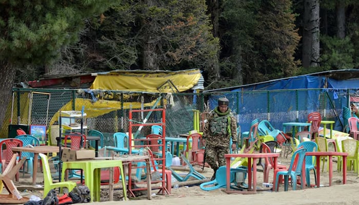 An Indian security force personnel walks amid toppled chairs and tables at the site of a suspected attack on tourists in Baisaran near Pahalgam in Indian Illegally Occupied Jammu and Kashmirs Anantnag district, April 23, 2025. — Reuters