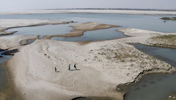 People walk on the dry patch of the Indus River, in Jamshoro, Pakistan March 15, 2025. — Reuters