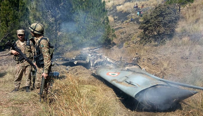Pakistani soldiers stand next to the wreckage of an Indian fighter jet shot down in Azad Kashmir at Somani area in Bhimbar district near the Line of Control on February 27, 2019.—AFP