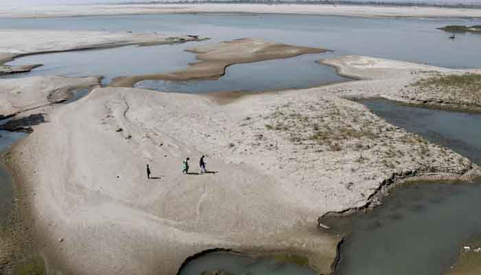 People walk on the dry patch of the Indus River, in Jamshoro, Pakistan March 15, 2025. — Reuters