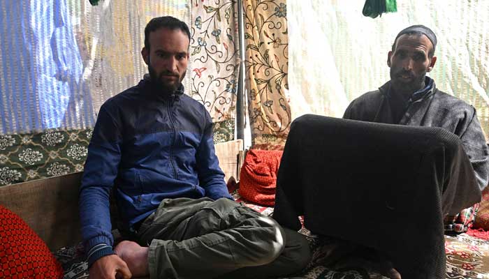 Syed Haidar Shah (right) and Naushad Hussain, the father and brother of slain Kashmiri horseman Syed Adil Shah, sit inside their village home at Hapatnar in Anantnag district on April 29, 2025. — AFP