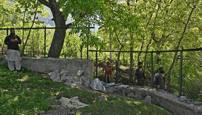 A relative offers prayers on the grave of slain Kashmiri horseman Syed Adil Shah, at Hapatnar in Anantnag district on April 29, 2025. — AFP