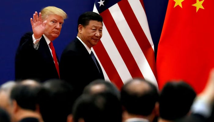 US President Donald Trump waves as he walks alongside Chinese President Xi Jinping. — Reuters/File