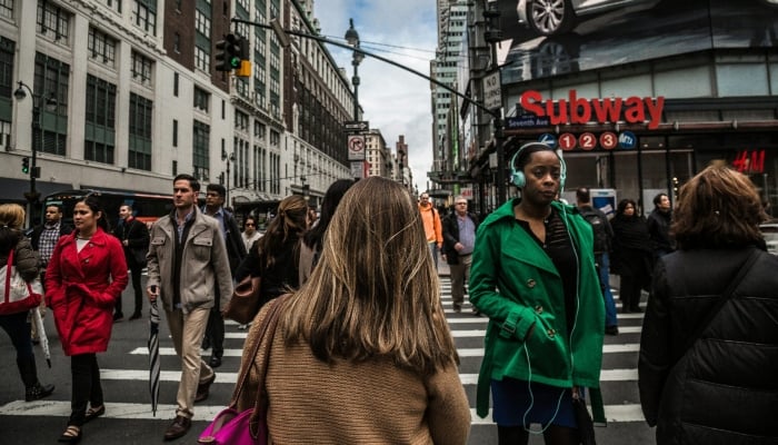 This image of representation shows people who walk on a road in New York, in the United States. - Unplash