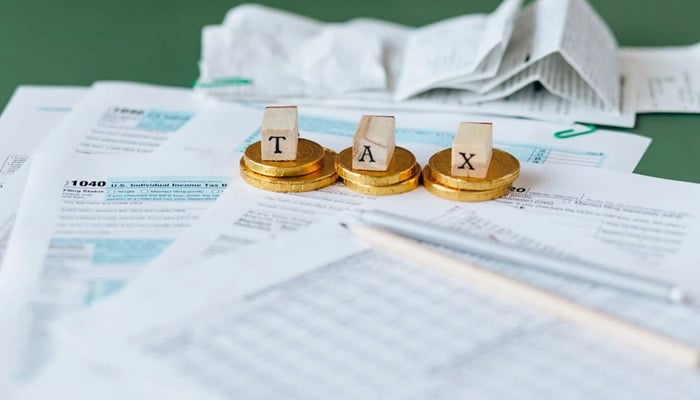 FBR under fire as complaints skyrocket by 550% in four months 1 A representational image of a table where coins and cubes with tax letters written on them are placed on the papers. — Pexels