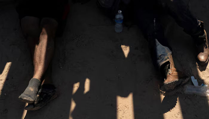 US court blocks Trump attempt to strip migrants' legal status 1 Asylum seeking migrants, mostly from Venezuela and Cuba, wait to be transported by US Customs and Border Protection agents after crossing the Rio Grande river into the US from Mexico at Eagle Pass, Texas, US, July 14, 2022. — Reuters