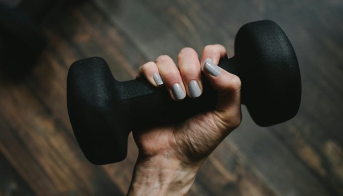 This representational image shows a persons hand holding a dumbbell. — Unsplash