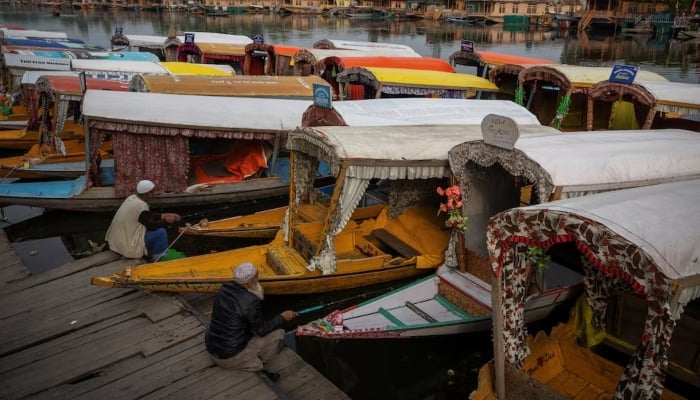 Kashmiri men catch fish as they sit next to parked Shikaras or boats on the banks of Dal Lake in Srinagar, IIOJK, May 4, 2025. — Reuters