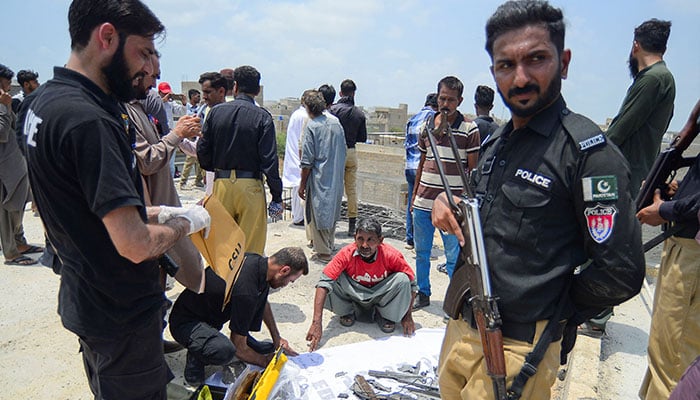 A member of the Crime Scene Unit (CSU) inspects the fragments, of what they say is a drone, after it was brought down, on the outskirts of Karachi May 8, 2025.  — Reuters