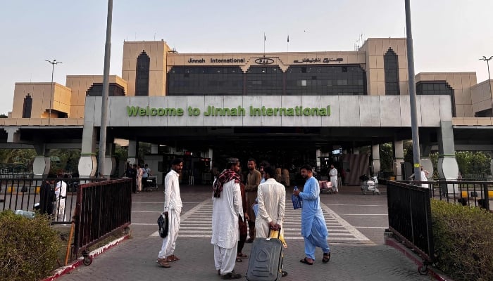 Passengers are waiting outside the Jinnah International Airport after all national and international flights were canceled in Karachi on May 7, 2025. —Afp