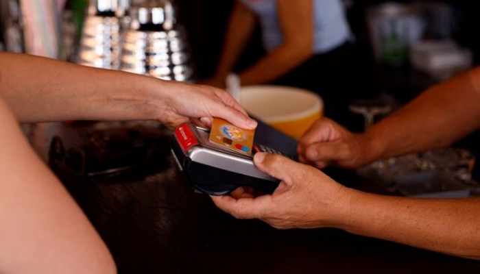 This image of representation shows a woman who pays with a credit card in a restaurant in Playa del Ingles, Maspalomas on the island of Gran Canaria, Spain, May 3, 2022. - Reuters