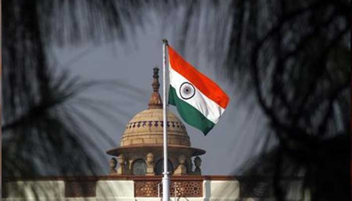 An Indian national flag flutters on top of the Indian parliament building in New Delhi on December 1, 2010. — Reuters