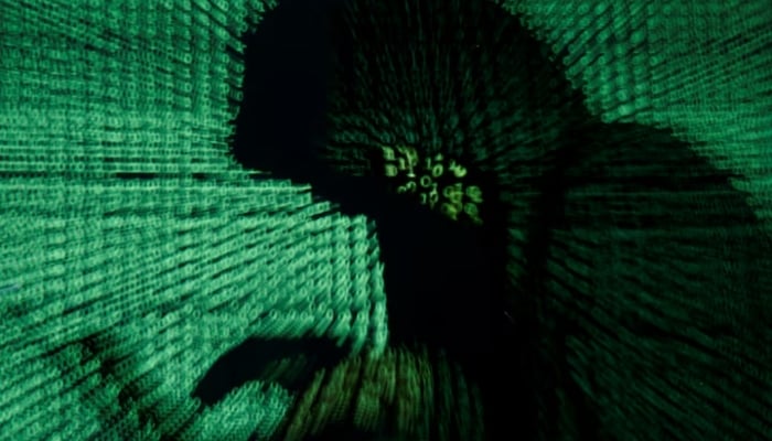 A man holds a laptop computer as cyber code is projected on him in this illustration picture. — Reuters