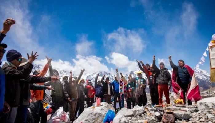 People pay tribute to Yala after Buddhist monks performed a ceremony for the glacier, with the Himalayas towering behind them on Monday. — AFP