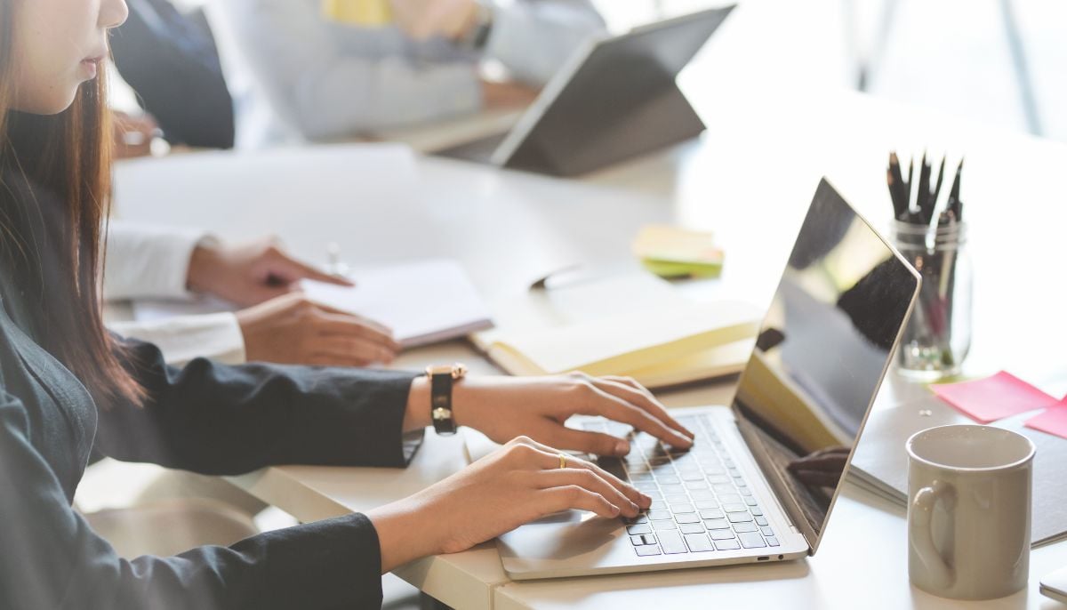 A representational image of a woman working on a laptop at work. — Canva
