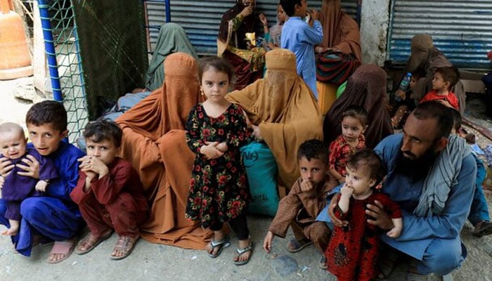 Muhammad Ismail, 40, sits with his family while they are waiting to cross main Afghanistan-Pakistan land border crossing, in Torkham, Pakistan September 15, 2023 — REUTERS