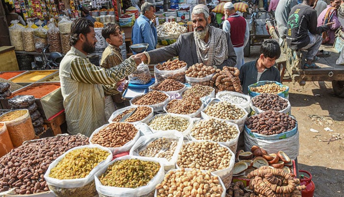 A street vendor sells dried fruits at a market in Karachi. — AFP/File