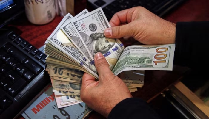 A money changer counts US dollar banknotes at a currency exchange office in Ankara, Turkey November 11, 2021. — Reuters