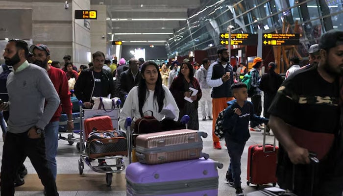 Travellers push carts with their luggage at the departure area of Terminal 3 at Indira Gandhi International Airport in New Delhi, India, December 14, 2022. — Reuters