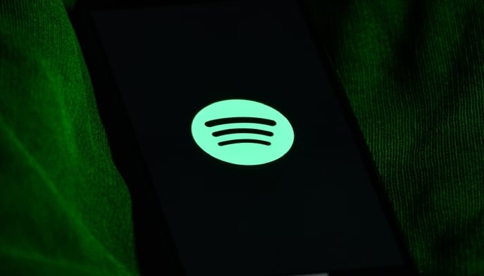 This representational image shows the Spotify logo displayed on a phone screen. — Unsplash