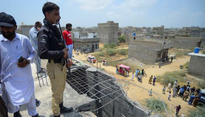 A police officer stands at the site where according to the Crime Scene Unit (CSU), a drone was brought down, on the outskirts of Karachi on May 8, 2025. — Reuters
