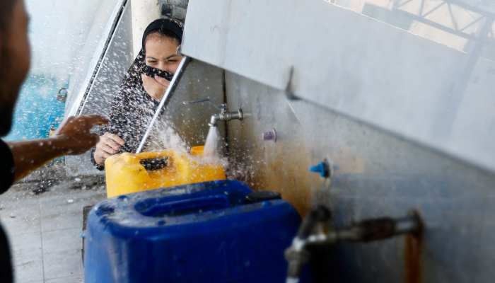 A girl reacts as Palestinians gather to fill water from public taps amid the conflict with Israel in Khan Younis, in the southern Gaza Strip, October 11, 2023. — Reuters