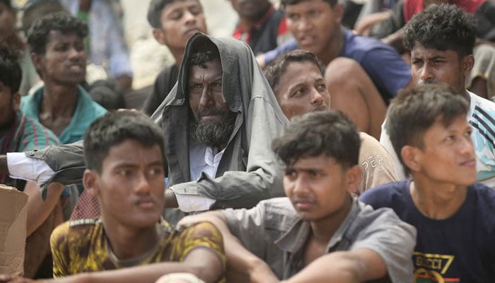 Rohingya Muslim men rest after landing on a beach in Sabang, Aceh province, Indonesia, November 22, 2023. — Reuters