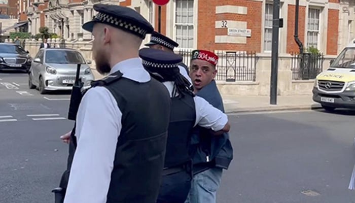Gulfam Hussain is being taken into custody by police in London. — Reporter